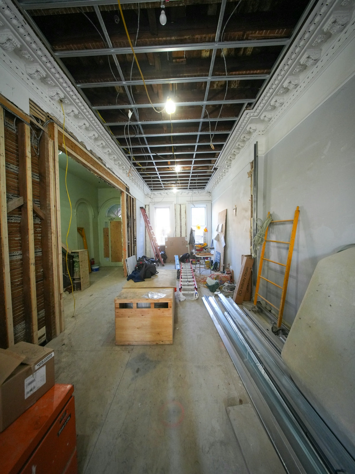 Interior hallway under construction with exposed ceiling and materials.