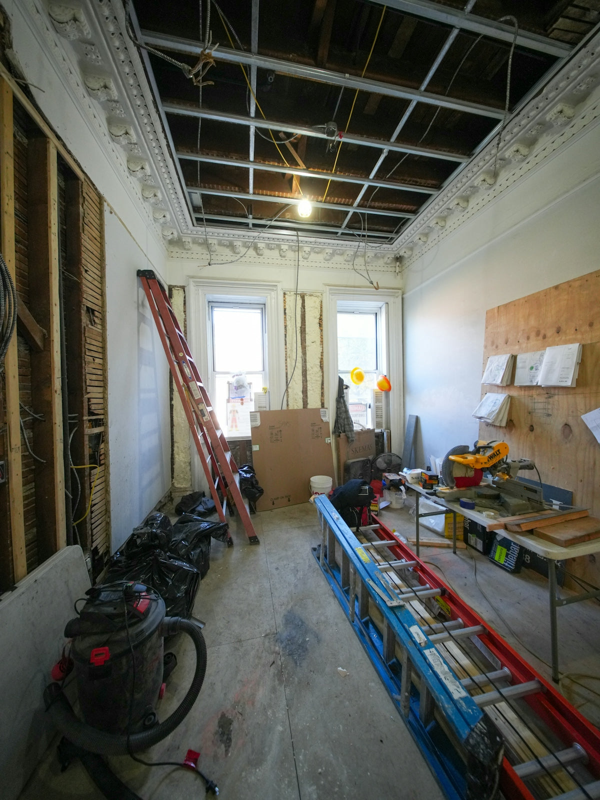 Room under construction with ladders and tools.